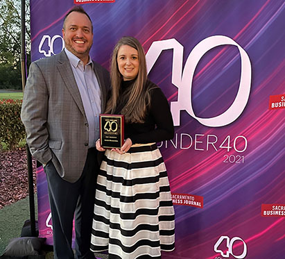 Kristin Mensonides, left, poses with her husband, Joel Mensonides, after being honored with 40 Under 40 recognition